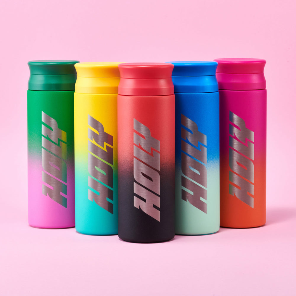 Fünf bunte Shaker mit dem Schriftzug "Holy" auf rosa Hintergrund.
